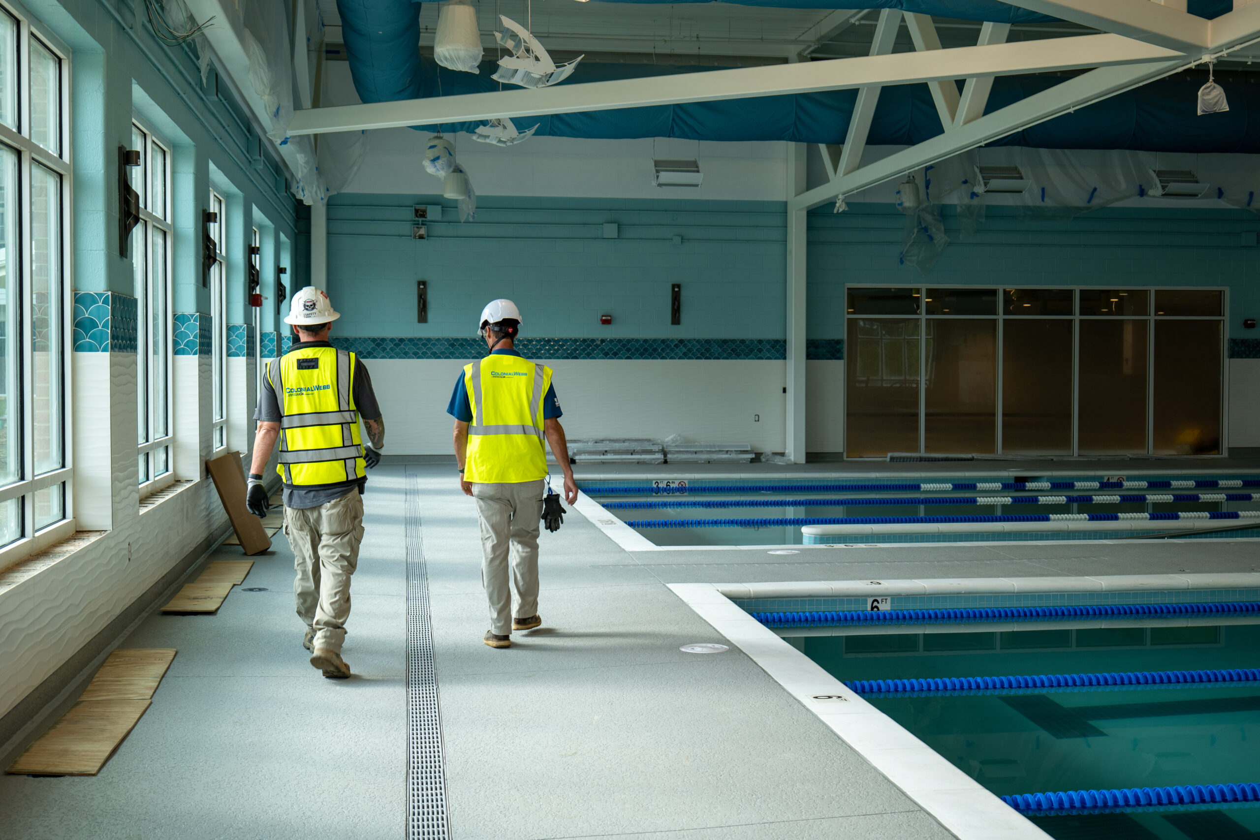 Superintendents doing walk through of job alongside indoor pool