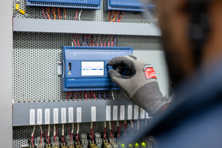 Technician adjusting a building automation system control panel